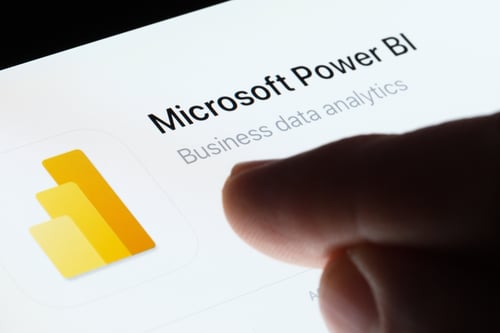 Image of a person pointing at the Power BI app Image of a person pointing at the Power BI app
